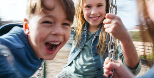 happy kids playing with swings