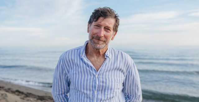 elderly man with striped shirt on beach