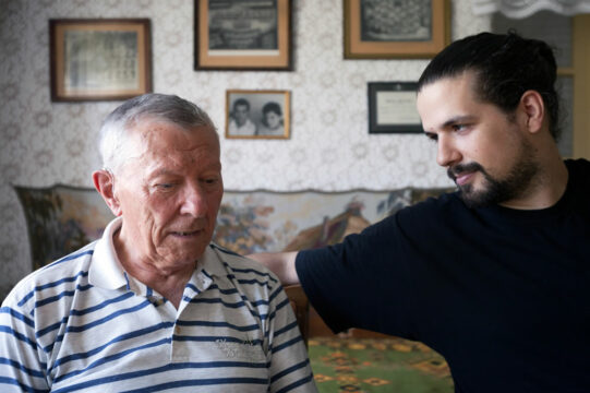 elderly man and son having a conversation